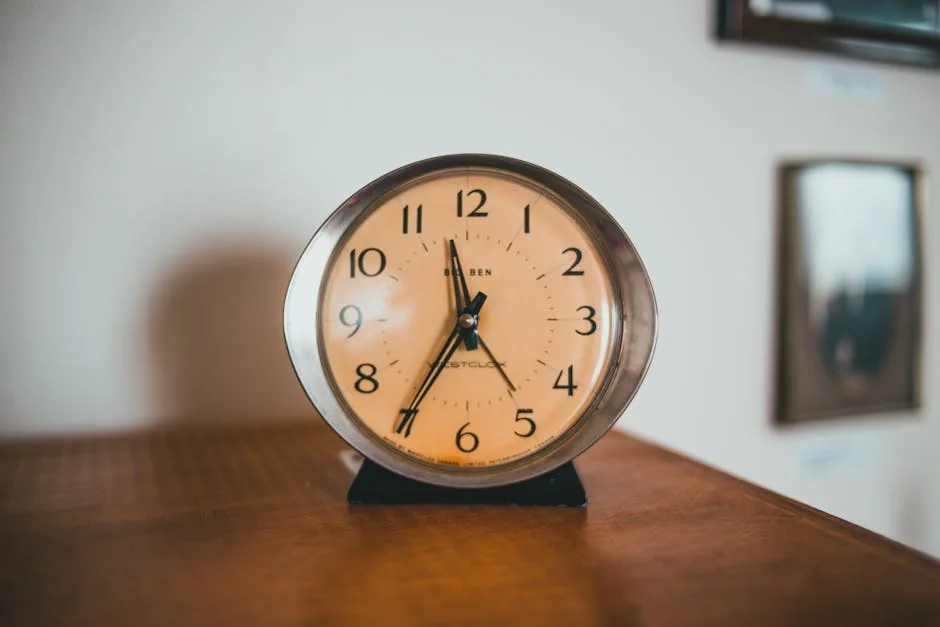 Close-up of a vintage alarm clock on a wooden surface with a warm, classic vibe.
